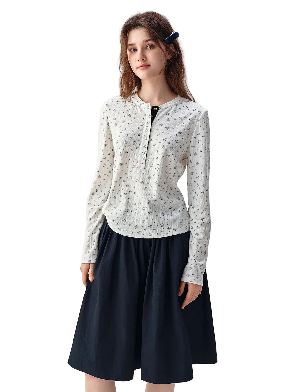 A woman modeling a Dushu long-sleeve blouse with a small floral print on an off-white base, paired with a dark navy skirt, against a plain white studio background.
