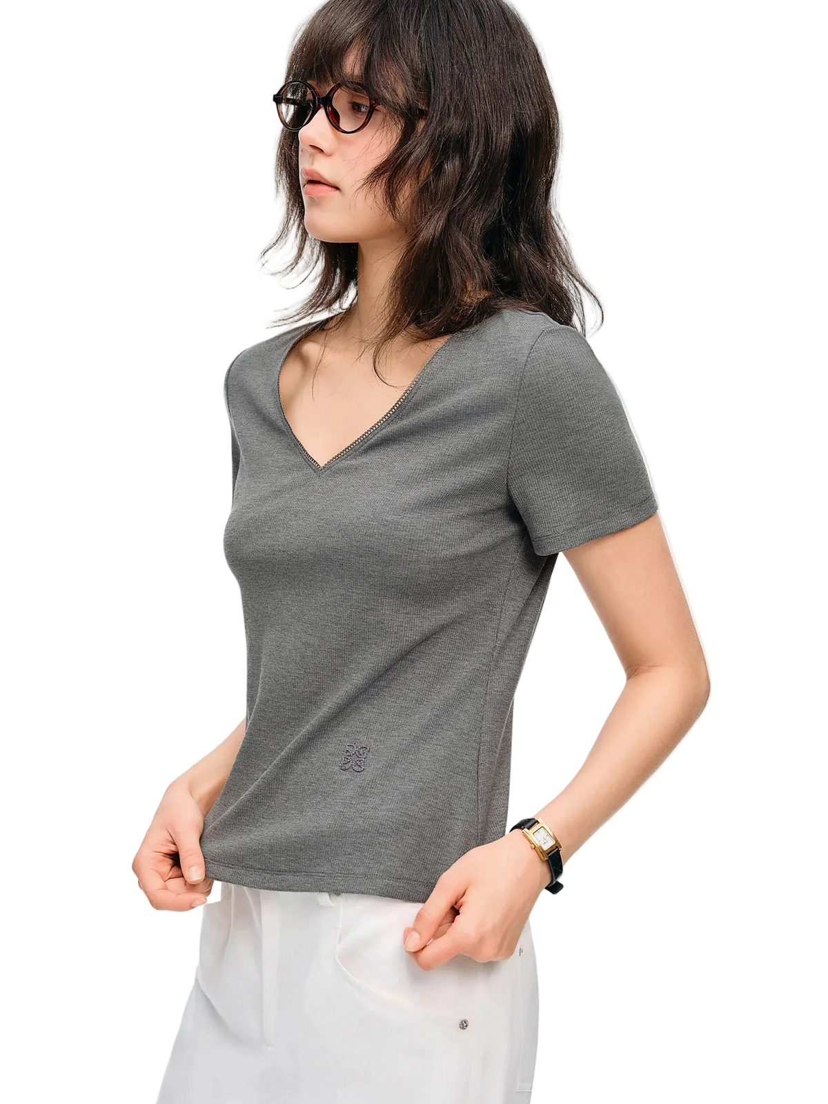 A woman wearing a fitted short-sleeve V-neck gray top and white pants, photographed against a plain white studio background. The brand name Dushu appears in the upper left corner.
