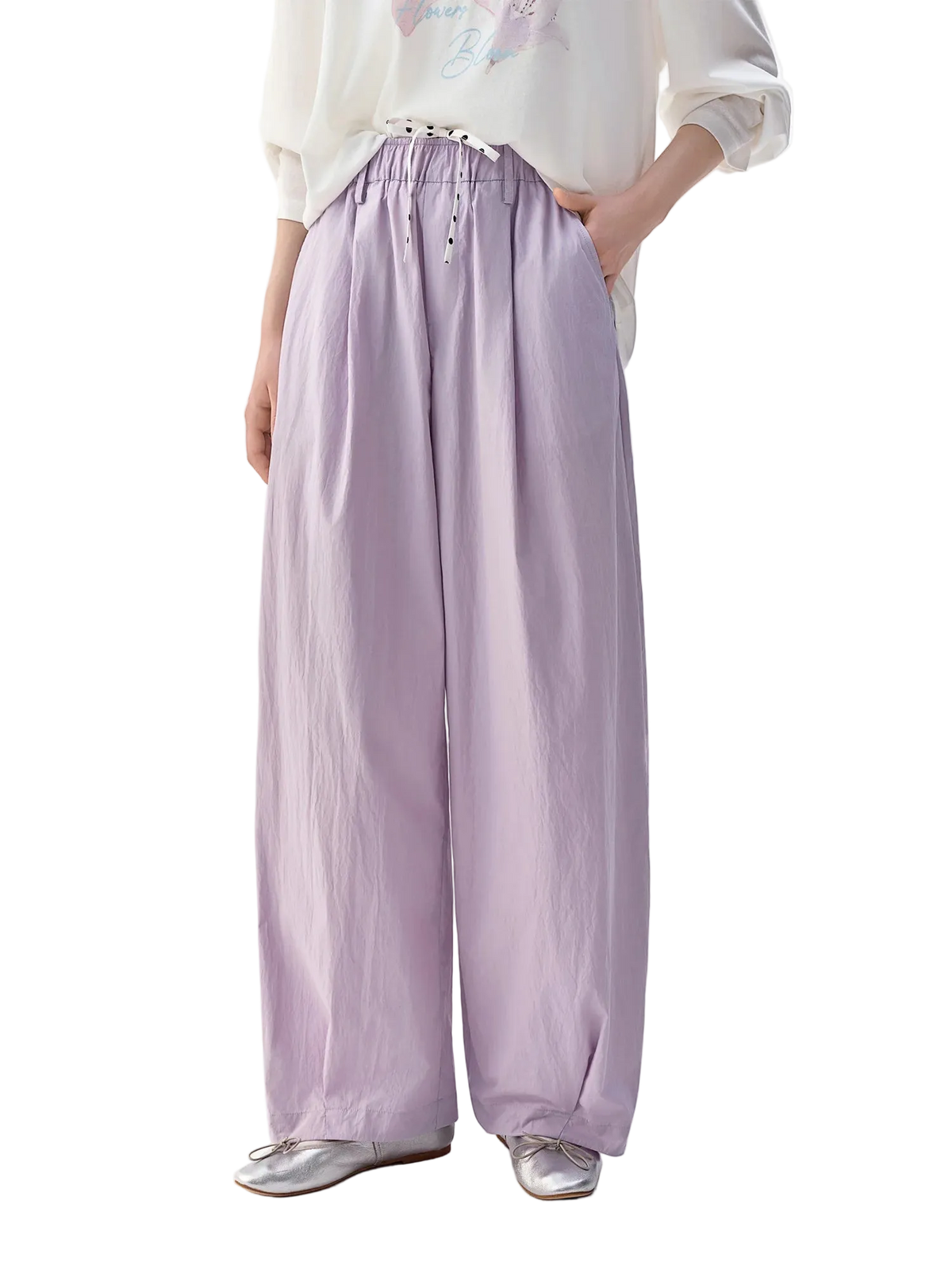 A model wearing Dushu light purple wide-leg pants with an elastic waistband and drawstring, paired with a white long-sleeve top and silver flat shoes, shown against a plain white background.