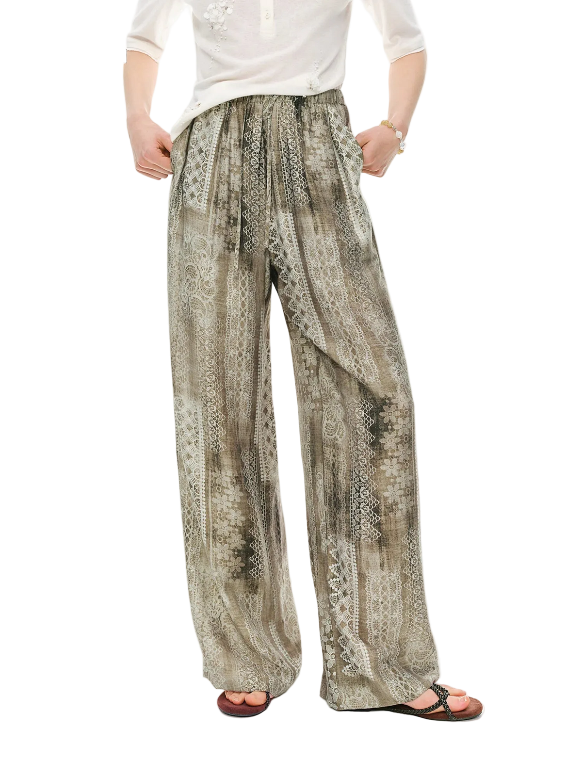 A person wearing loose, wide-leg pants with an abstract snakeskin-style print in beige, gray, and brown tones, paired with a white top and sandals. The Dushu brand name is visible in the top-left corner on a plain white background.